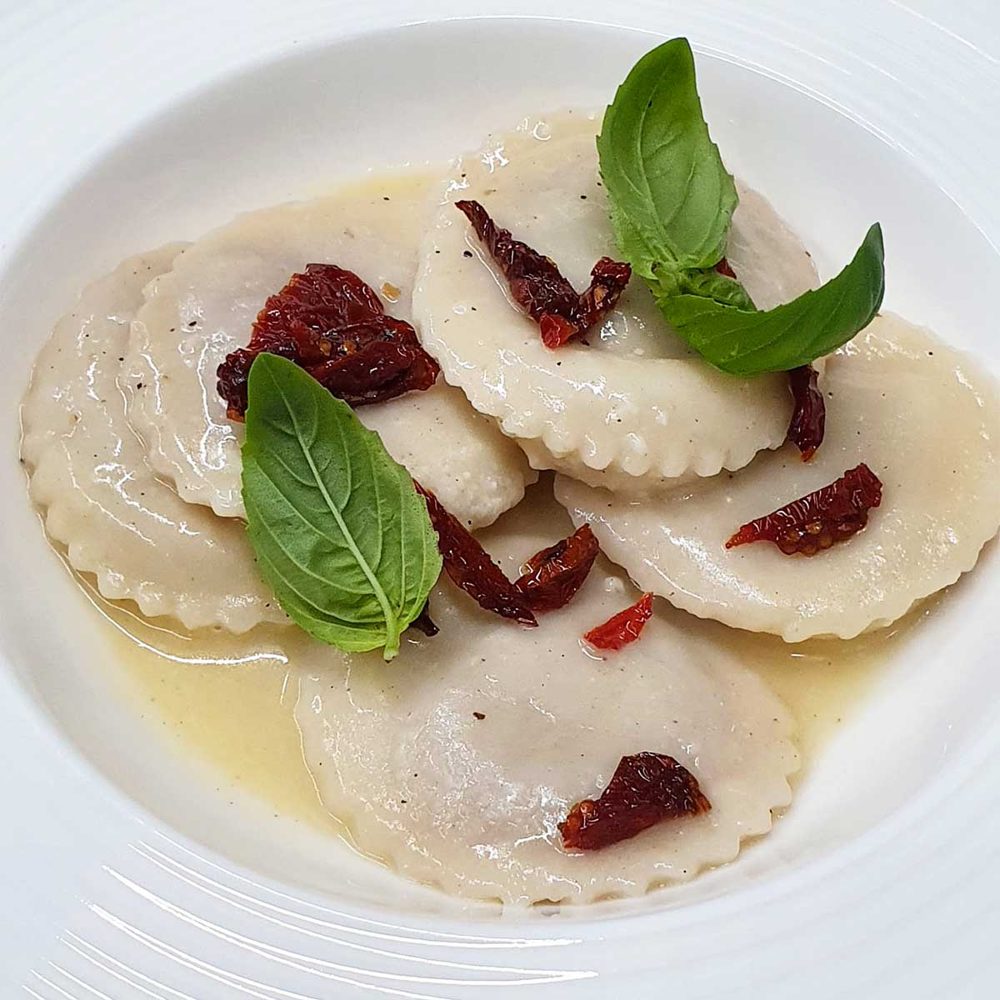 Raviolo ripieno di parmigiana melanzane salsa cacio e pepe guanciale croccante